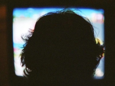 Child watching TV in the dark.