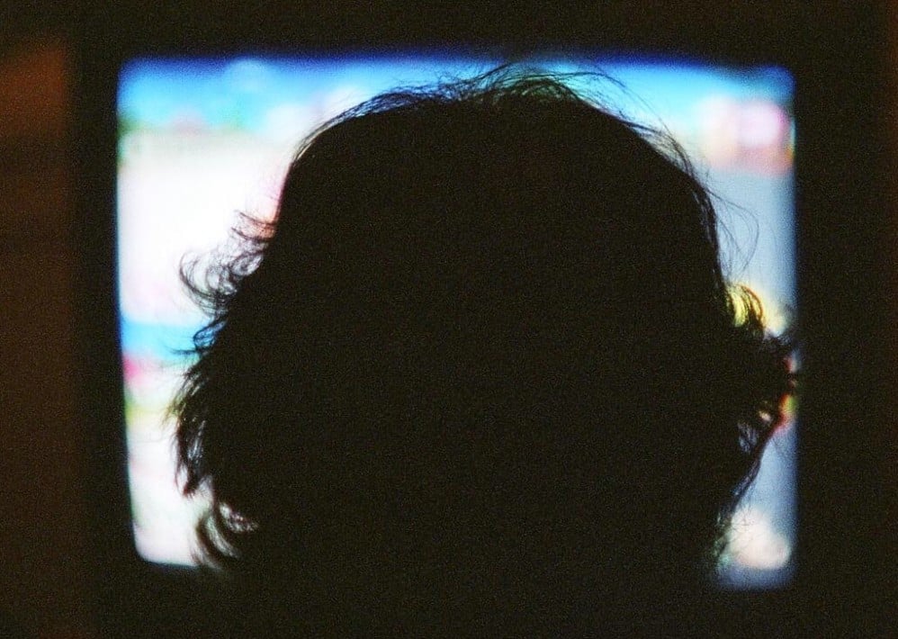 Child watching TV in the dark.