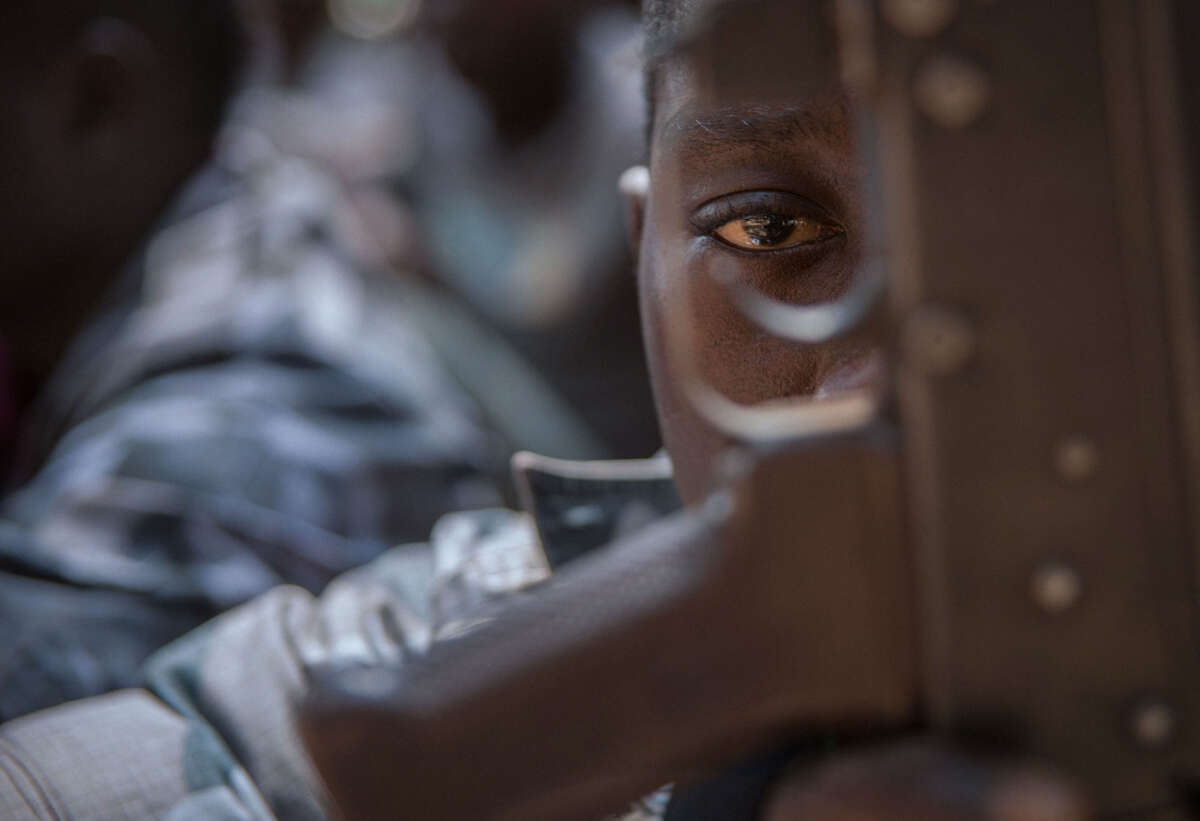 A newly released child soldier looks through a rifle trigger guard during a release ceremony for child soldiers in Yambio, South Sudan, on February 7, 2018.