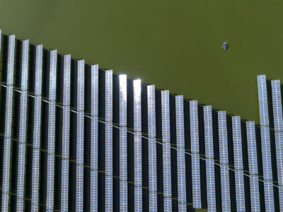 This photo taken on November 14, 2018, shows Chinese fishermen next to a photovoltaic power station built on top of fish ponds in Yangzhou in China's eastern Jiangsu province. A new report by IEA and IRENA is the latest attempt to address the question of global temperatures.