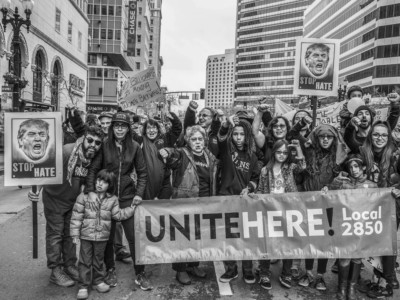 The Women's March Against Trump in Oakland - Women from community organizations and unions in Oakland, together with men, marched through the downtown district, carrying banners and blocking streets, to protest the inauguration of Donald Trump as U.S. President, at the same time the inauguration was taking place in Washington DC. Members and organizers of Unitehere Local 2850, the union for hotel and restaurant workers in the East Bay, turn thumbs down on the idea of Trump as President.