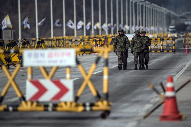 South Korean soldiers patrol the road connecting South and North Korea at the Unification Bridge near the Demilitarized Zone (DMZ) on February 7, 2018, near Panmunjom, South Korea. According to a new report, leaders of the two countries may discuss returning the heavily fortified DMZ separating them to its original state.