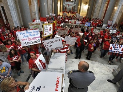 Kentucky public school teachers protest outside the Kentucky House Chamber as they rally for a day of action to pressure legislators to override Gov. Matt Bevin's recent veto of the state's tax and budget bills, April 13, 2018, in Frankfort, Kentucky. The teachers also oppose a controversial pension reform bill the governor signed into law.