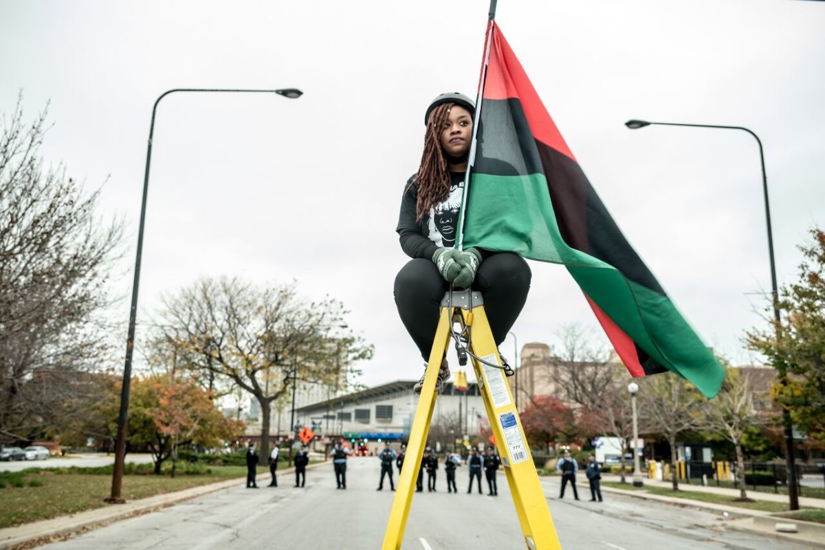 An activist holds a Pan-African flag during a protest disrupting the Association of Chiefs of Police Conference on October 25, 2015, in Chicago, Illinois.