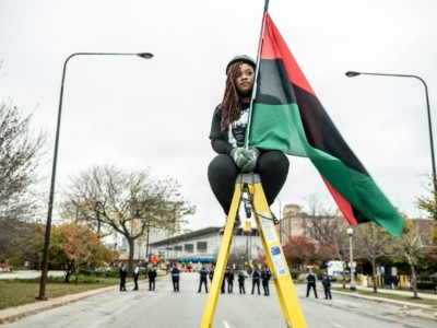 An activist holds a Pan-African flag during a protest disrupting the Association of Chiefs of Police Conference on October 25, 2015, in Chicago, Illinois.