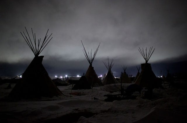 Giant flood lights set up by a pipeline company and law enforcement illuminate a cloudy winter night at the Oceti Sakowin camp just outside of the Lakota Sioux reservation of Standing Rock, North Dakota, on December 1, 2016.