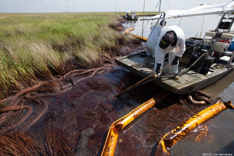 BP oil spill cleanup workers, without respirators, deal with oiled absorbant boom in 2010.