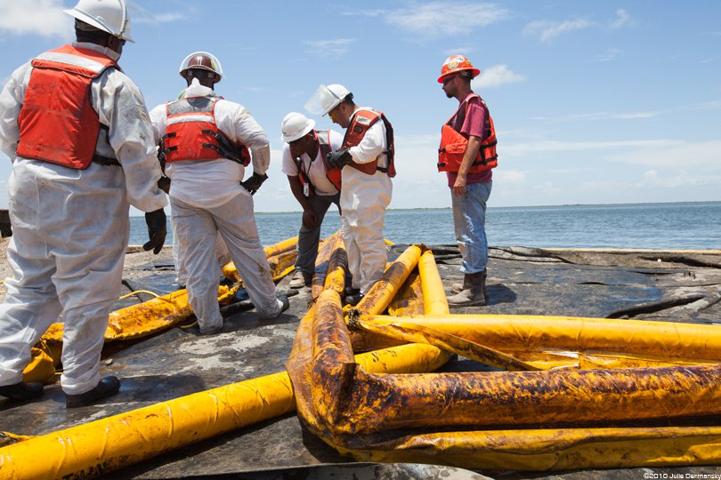 BP oil spill workers with oiled boom in 2010.