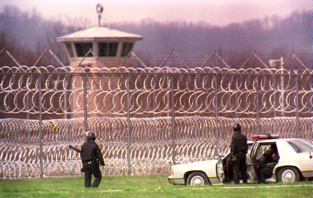 Police officers patrol the outer perimeter of the Southern Ohio Correctional Facility April 12, 1993, after a prisoner uprising on April 11, 1993.