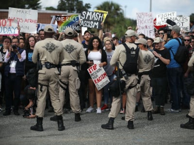 Protesters are held behind a line of police as they demonstrate against white nationalist Richard Spencer's speech at the Curtis M. Phillips Center for the Performing Arts on October 19, 2017, in Gainesville, Florida.