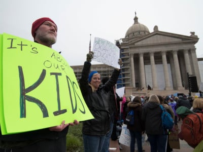 Kent Scott, a teacher from Tecumseh, Oklahoma, holds a protest sign at the state capitol on April 2, 2018, in Oklahoma City, Oklahoma. Thousands of teachers and supporters rallied Monday at the state Capitol calling for higher wages and better school funding.