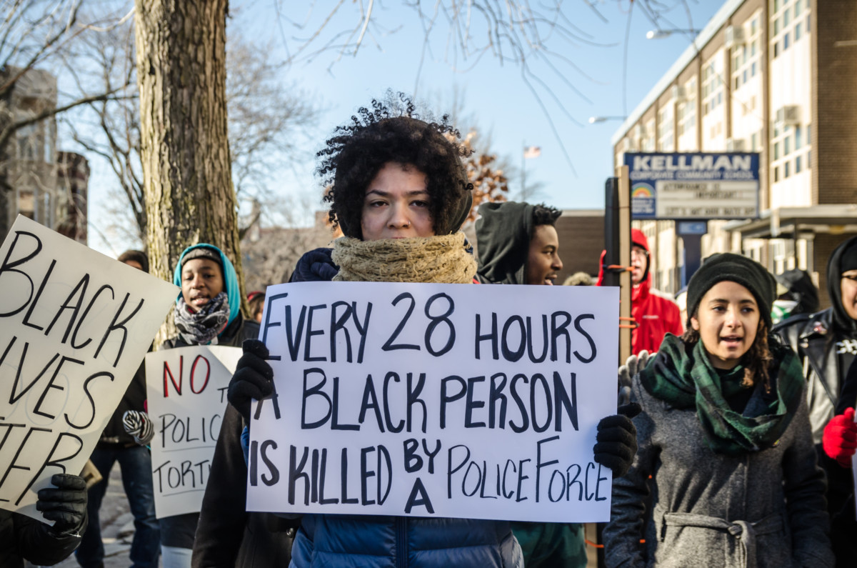 An activist displays a sign during the BYP100 #DecriminalizeBlack protest on December 21, 2014, in Chicago, Illinois.