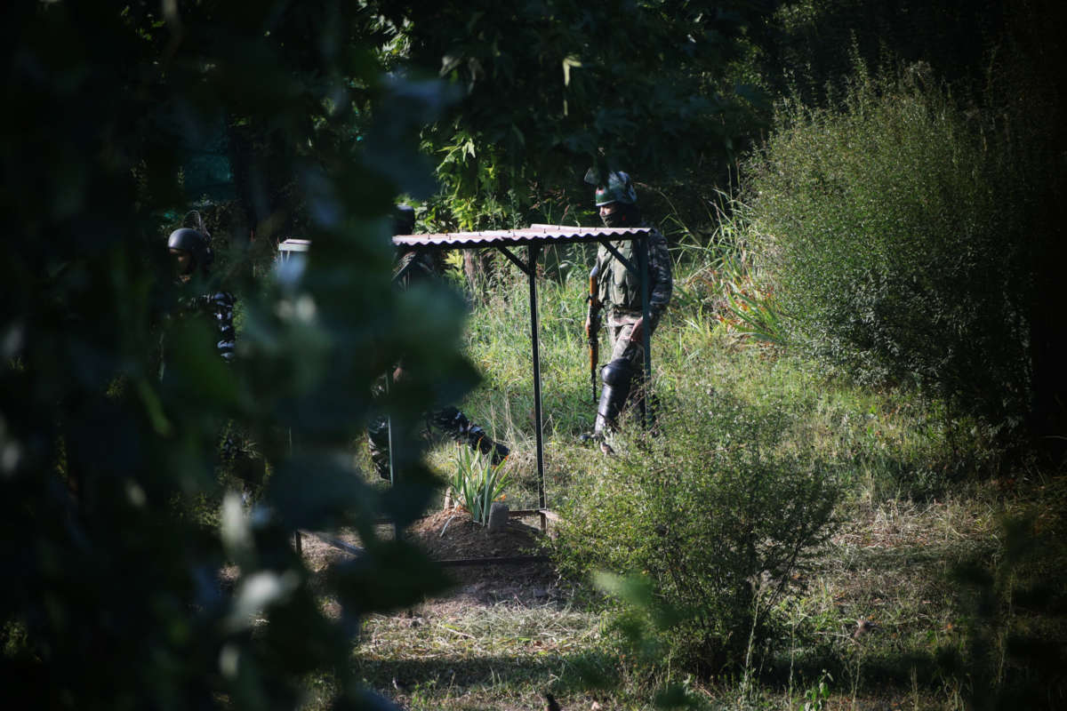 Paramilitary forces patrol the grave of Syed Ali Shah Geelani.