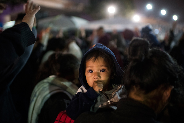 A prayer service is held for the group of Central American migrants at the San Ysidro border crossing while they wait to walk to the United States border and have their cases processed on April 30, 2018, in Tijuana, Mexico.