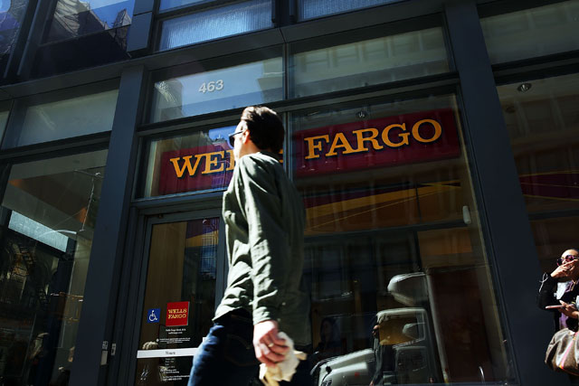 Pedestrians pass a Wells Fargo bank branch in lower Manhattan on April 15, 2016 in New York City. Markets and commercial banks rely on the monetary policies of central banks.