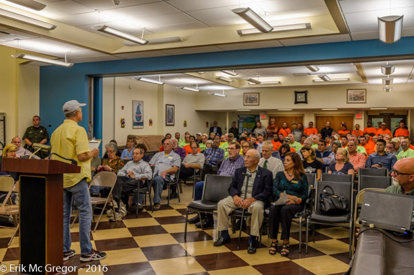 Orange-shirted participants at a Spectra Energy public comment hearing for its Atlantic Bridge Project, the second of three segments of one pipeline. Like other infrastructure purveyors, Spectra segments projects to avoid responsibility for cumulative impacts.