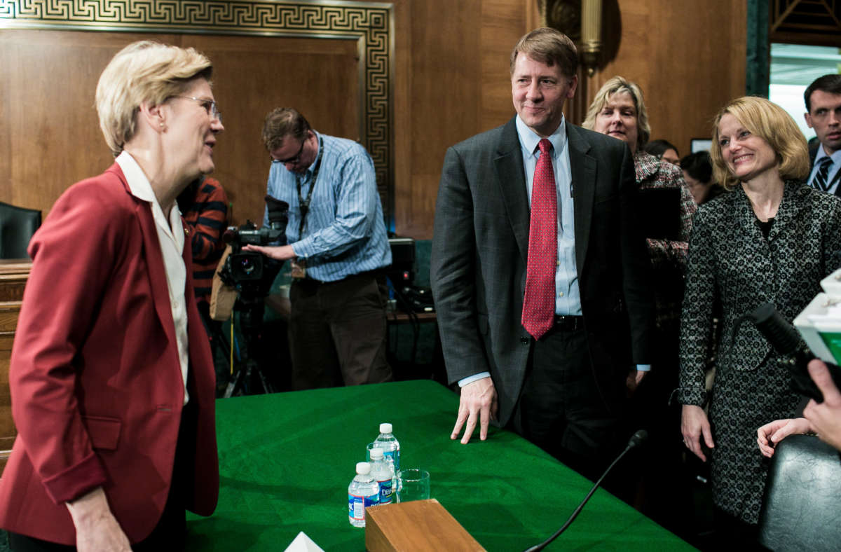 Sen. Elizabeth Warren. left, speaks with Richard Cordray, center, nominee for director of the Consumer Financial Protection Bureau, after a confirmation hearing in the Senate Committee on Banking, Housing and Urban Affairs on March 12, 2013, in Washington, D.C.