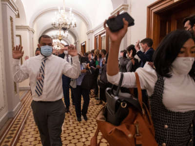 Congressional staff members are evacuated after Trump supporters breached the U.S. Capitol, interrupting a joint congressional session to certify the Electoral College vote in Washington, D.C., on Wednesday, January 6, 2021.