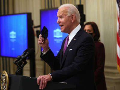 President Biden holds up a mask as Vice President Kamala Harris looks on during an event at the State Dining Room of the White House January 21, 2021, in Washington, D.C.