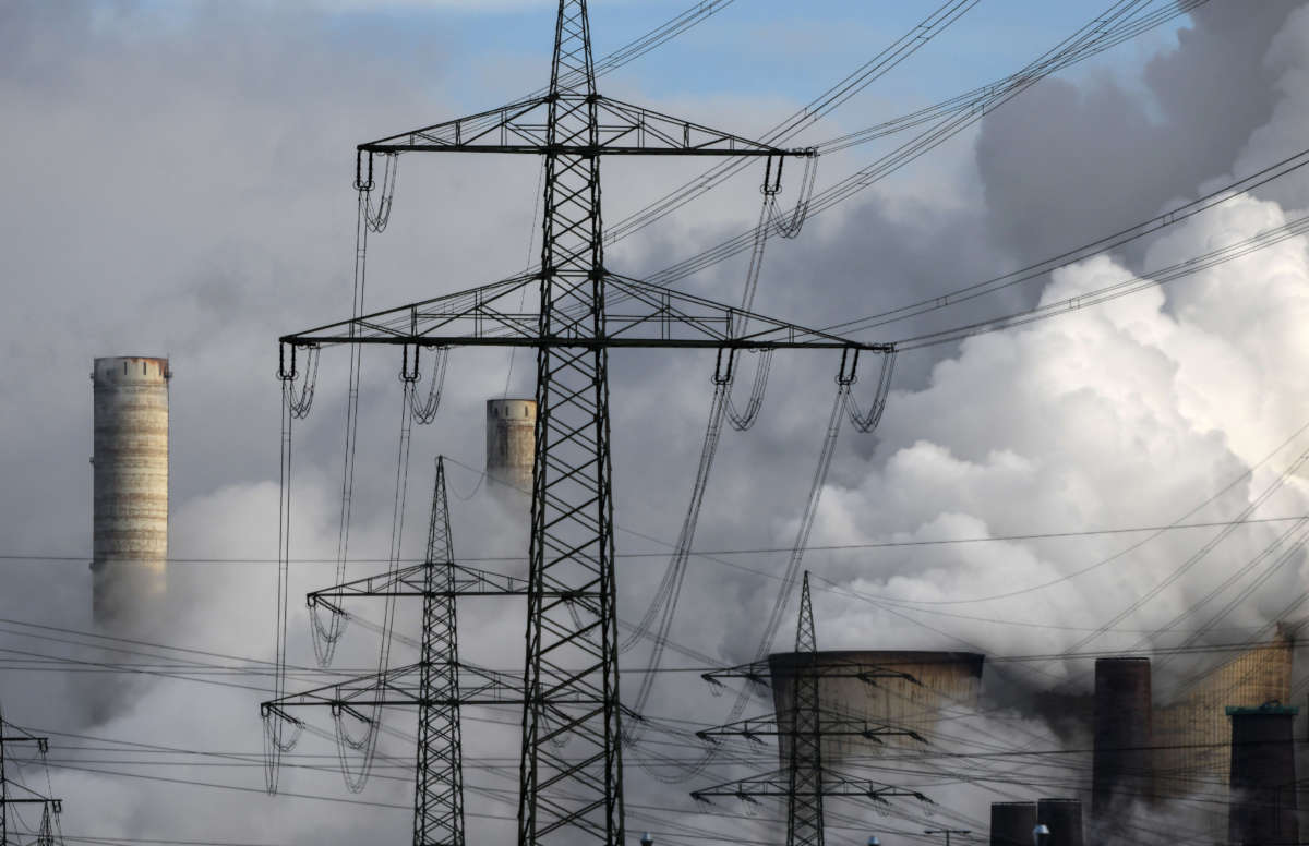 Electricity pylons are seen in front of the cooling towers of a coal-fired power station in Weisweiler, western Germany, on January 26, 2021.