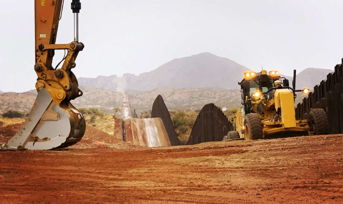 Workers move sections of the border wall on January 20, 2021, in Sasabe, Arizona.