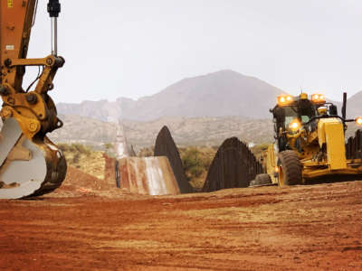 Workers move sections of the border wall on January 20, 2021, in Sasabe, Arizona.