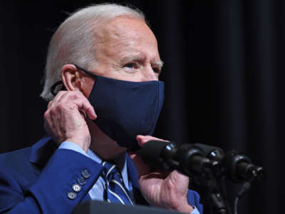 President Biden adjusts his mask as he speaks during a visit to the National Institutes of Health in Bethesda, Maryland, on February 11, 2021.