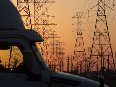 A truck passes a row of high voltage transmission towers on February 21, 2021, in Houston, Texas.