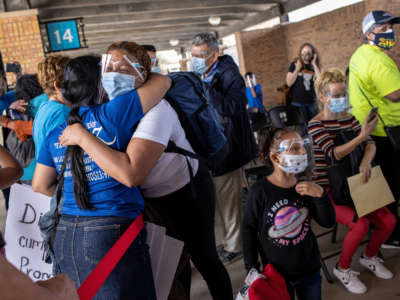 An asylum seeker embraces an immigration volunteer upon her arrival to the United States on February 26, 2021, in Brownsville, Texas.