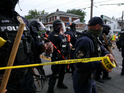 Louisville Metro Police Department put up police tape in Louisville, Kentucky, as protestors march on September 23, 2020.