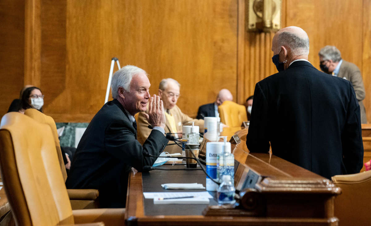 Sen. Ron Johnson (left) speaks to Sen. Rick Scott prior to a confirmation hearing before the Senate Budget Committee on February 10, 2021, at the U.S. Capitol in Washington, D.C.