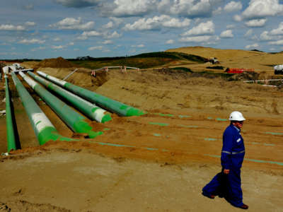 A facilities manager at the Keystone facility passes by the pipes that would connect the existing Keystone operation with the new expanded Keystone XL on June 21, 2012.