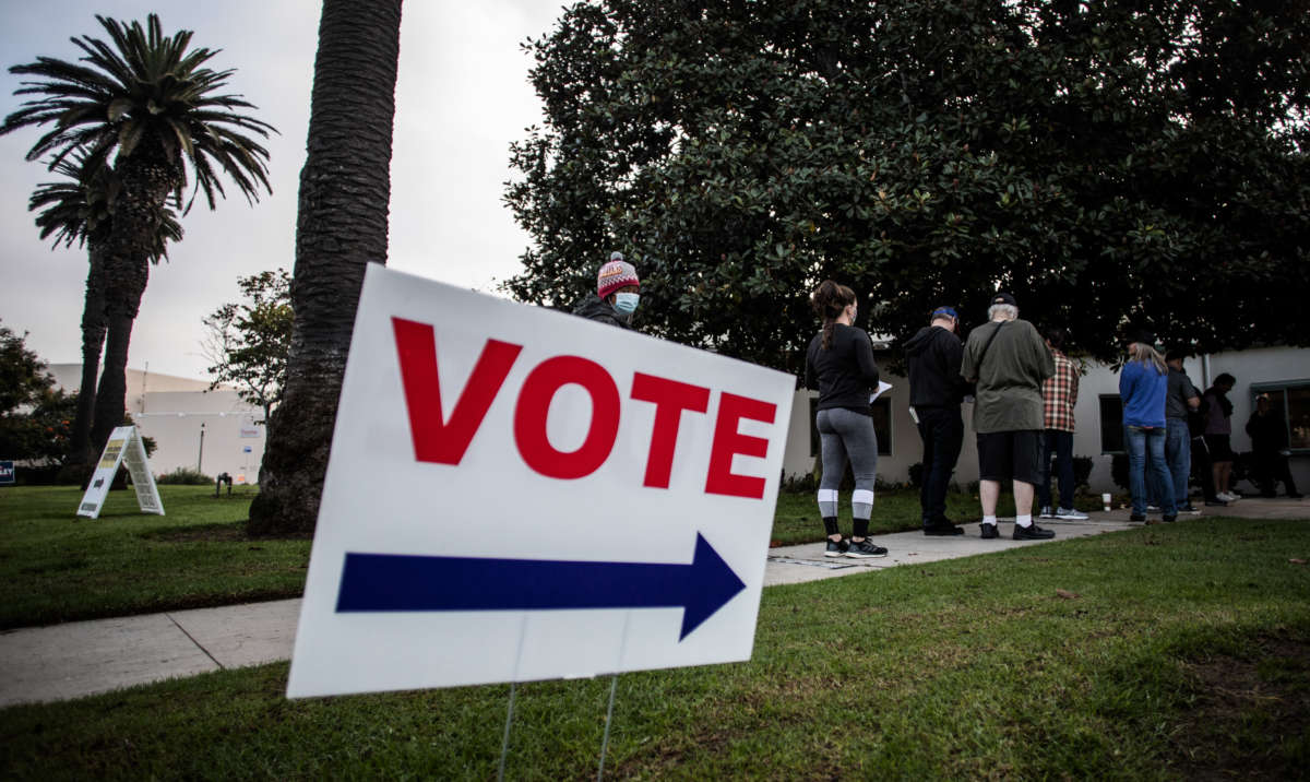 People stand in line to vote outside the Main Street Branch Library vote center on November 3, 2020, in Huntington Beach, California.