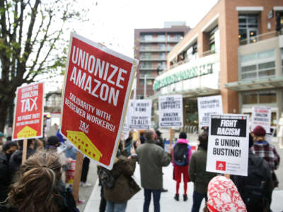 People hold pro-union signs and rally outside a Whole Foods Market after marching from Amazon headquarters in solidarity with Amazon workers in Bessemer, Alabama, who hope to unionize, in Seattle, Washington, on March 26, 2021.