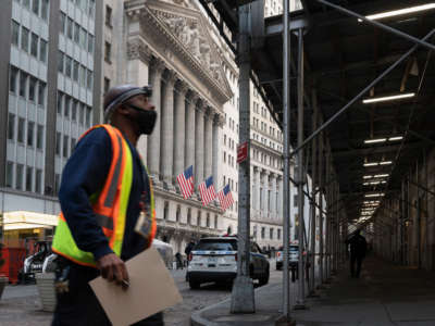 A man walks past the New York Stock Exchange on Wall Street on March 23, 2021, in New York City.