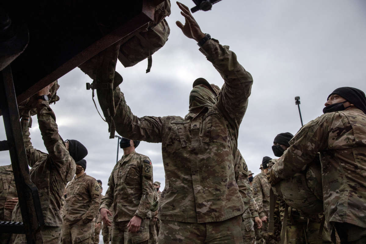 U.S. Army soldiers retrieve their duffel bags after they returned home from a 9-month deployment to Afghanistan on December 10, 2020, at Fort Drum, New York.