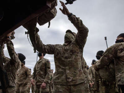 U.S. Army soldiers retrieve their duffel bags after they returned home from a 9-month deployment to Afghanistan on December 10, 2020, at Fort Drum, New York.