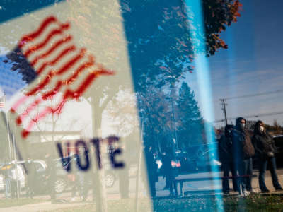 People wait in line to cast their absentee ballots in person at the Sterling Heights Election Center located in the Senior Center in Sterling Heights, Michigan, on November 2, 2020.