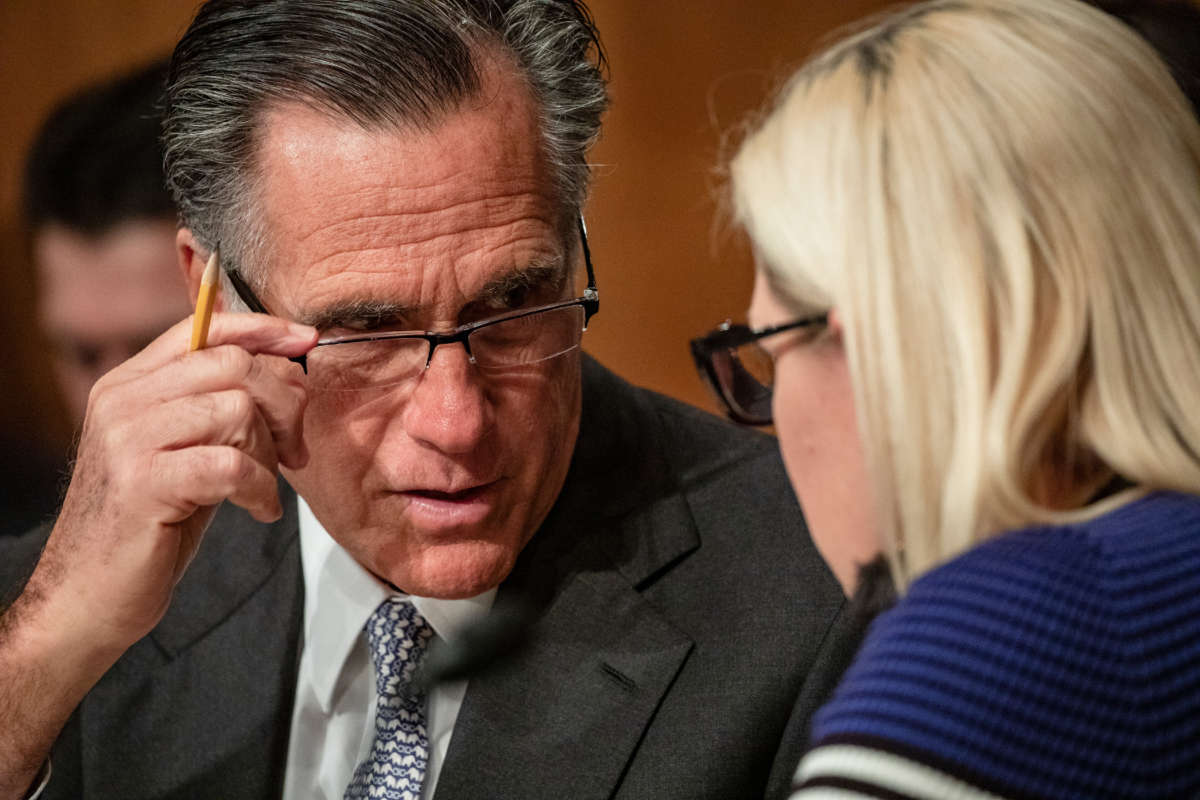 Sens. Mitt Romney and Kyrsten Sinema speak to each other during a Senate Homeland Security Committee hearing on March 5, 2020, in Washington, D.C.