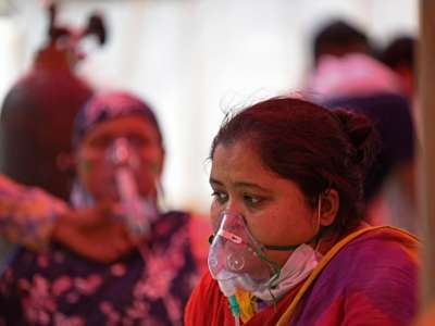 A woman wears an oxygen mask