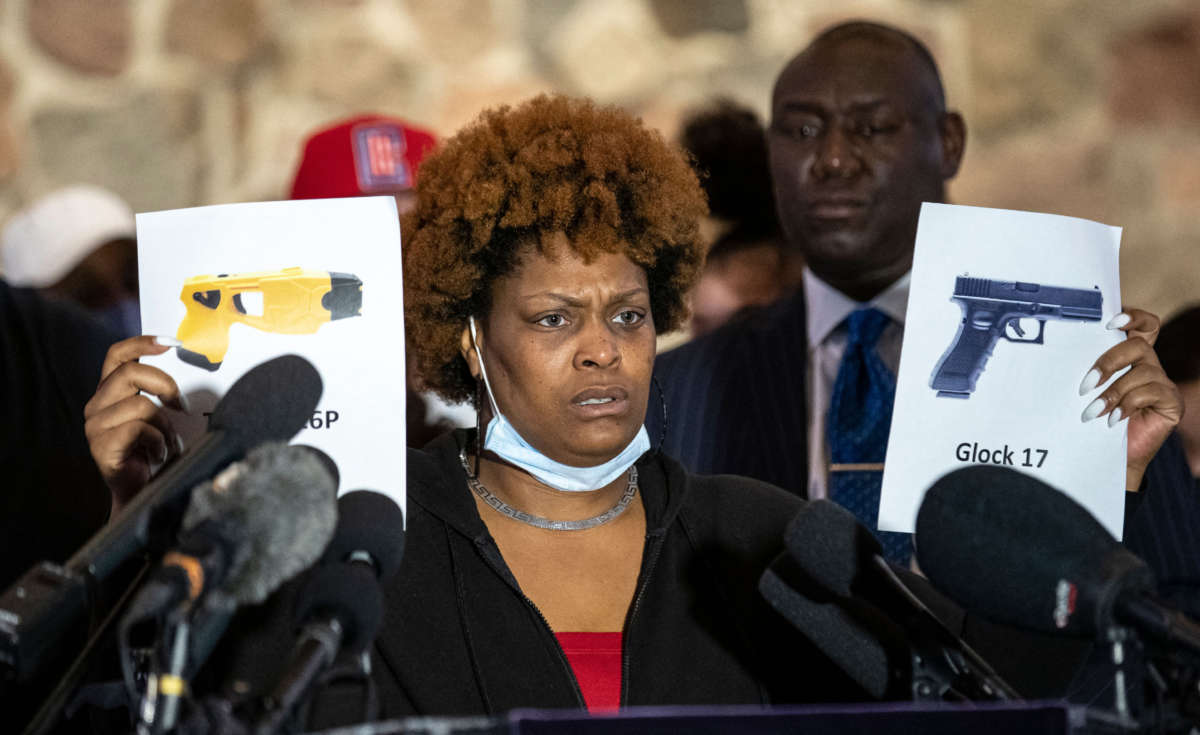 Naisha Wright, Daunte Wright's aunt, shows pictures of a Glock 17 and a Taser X26P during a press conference at New Salem Missionary Church in Minneapolis, Minnesota, on April 15, 2021.