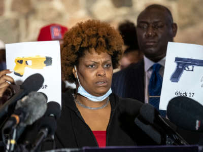 Naisha Wright, Daunte Wright's aunt, shows pictures of a Glock 17 and a Taser X26P during a press conference at New Salem Missionary Church in Minneapolis, Minnesota, on April 15, 2021.