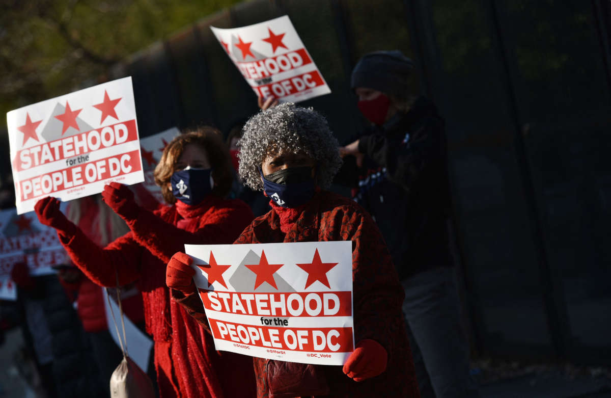 Activists hold signs as they take part in a rally in support of D.C. statehood near the U.S. Capitol in Washington, D.C., on March 22, 2021.