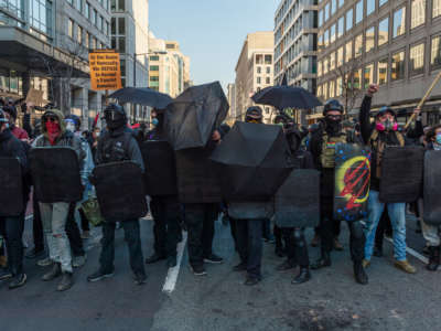 Counter-protesters form a line outside of Black Lives Matter Plaza against a police line separating them from a group of Proud Boys during an anti-Trump rally on the same day as the second Million MAGA March in Washington, D.C., on December 12, 2020.