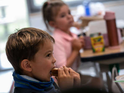 Children eat lunch at their desks as a coronavirus safety protocol on their first day of kindergarten on September 9, 2020, in Stamford, Connecticut.