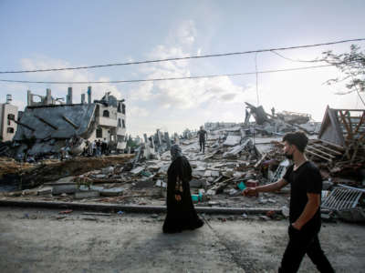 A Palestinian woman inspects her destroyed house after an Israeli air strike in Beit Lahia, on the northern Gaza strip, on May 13, 2021.