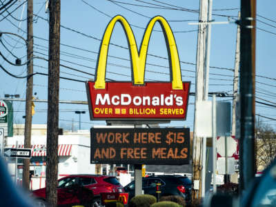 The sign at the McDonald's restaurant on Penn Ave in Sinking Spring, Pennsylvania, on April 8, 2021, with a message on a board below it that reads "Work Here $15 And Free Meals."