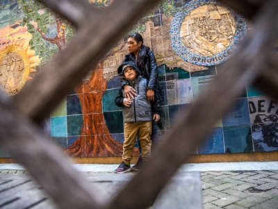 Juthaporn Chaloeicheep, 44, and son Douglas Jones, 5, stand for a portrait in the courtyard of Arnett Watson Apartments, a permanent supportive housing community where they reside in the Tenderloin district of San Francisco, California, on March 16, 2021.