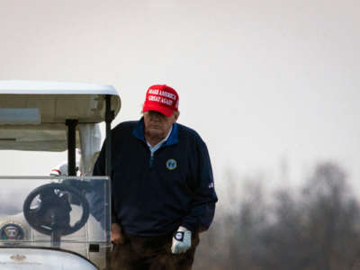 Then-President Donald Trump climbs into golf cart number 45 as he golfs at Trump National Golf Club on December 13, 2020, in Sterling, Virginia.