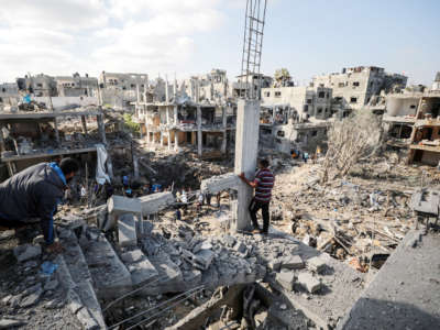 Palestinians search for their belongings while rescue efforts continue to evacuate Palestinians from the rubble of the buildings destroyed by ongoing Israeli airstrikes on Gaza, in Beit Hanoun, Gaza on May 14, 2021.